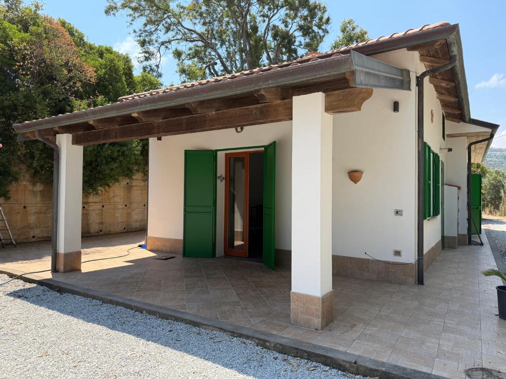 a small house with green and white walls at Marinella Retreat - Sole in Zambrone