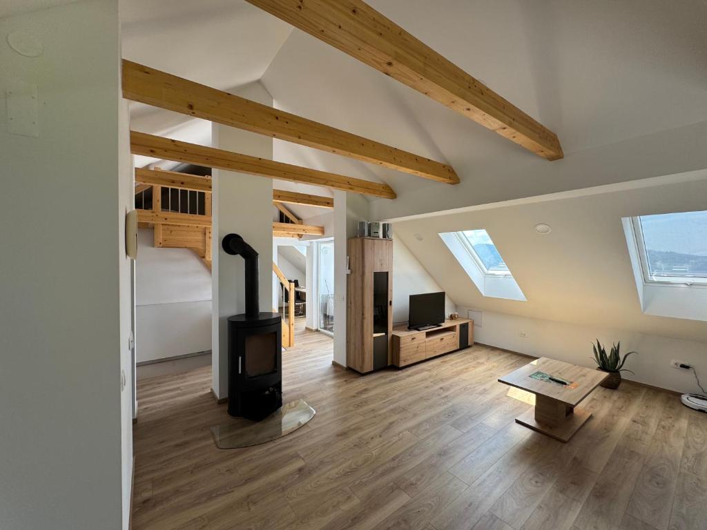 a living room with a wood stove in a loft at Apartma Pr`mejač in Laze v Tuhinju