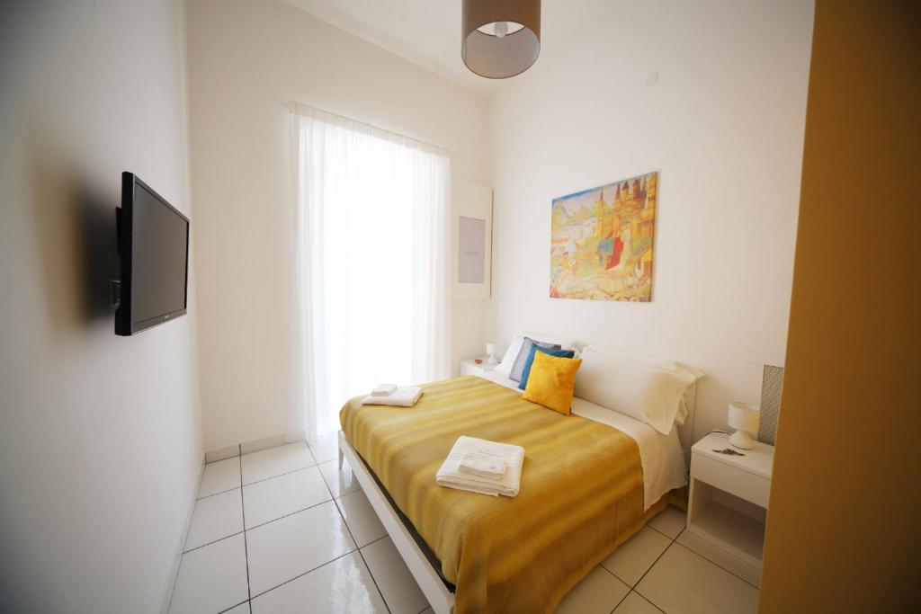 Dormitorio pequeño con cama y TV en Le Mulieres, en Salerno