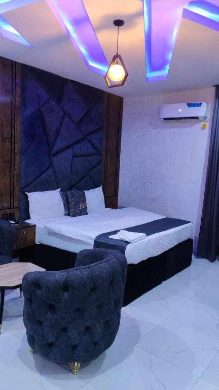 a hotel room with a bed and a chair at Indian Atlantic Hotel & Suites in Agbor