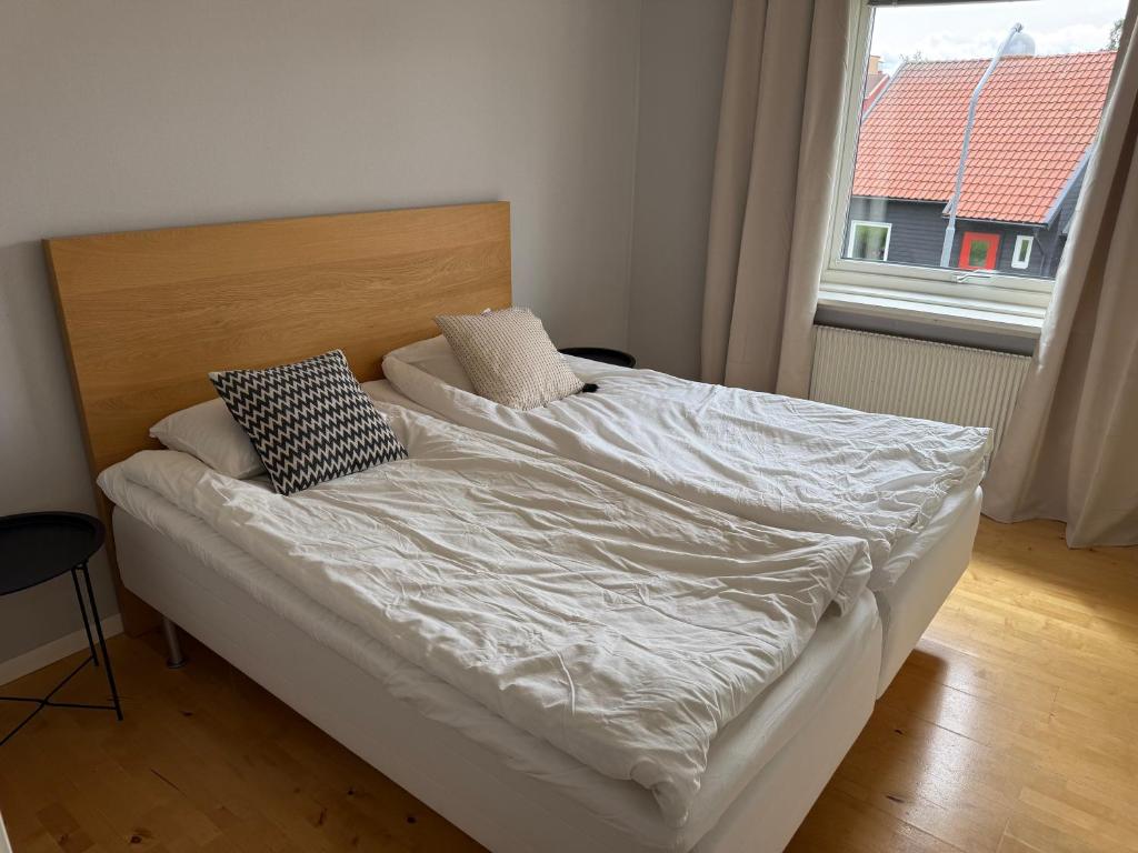 a bed with white sheets and pillows in a bedroom at Hardangegatan in Östersund
