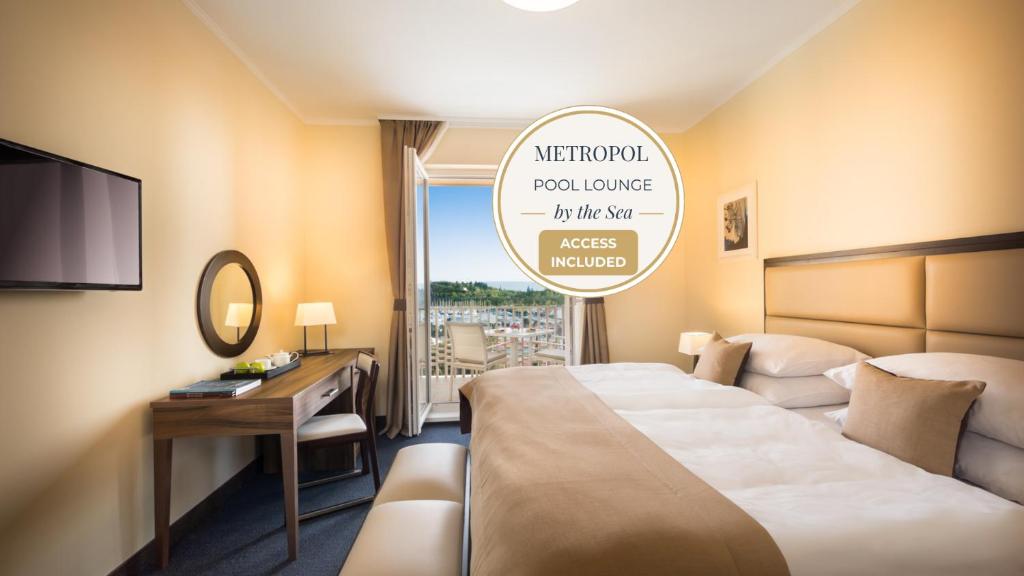 a hotel room with a bed and a desk and a window at Remisens Casa Rosa, depandansa hotela Metropol in Portorož