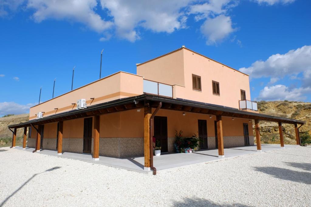 a large building with wooden pillars in front of it at Villa Silla - Casa Vacanze in Delia