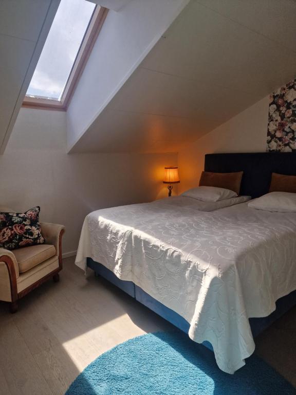 ein Schlafzimmer mit einem Bett, einem Stuhl und einem Fenster in der Unterkunft Cozy apartment Sofia in Fjälkinge