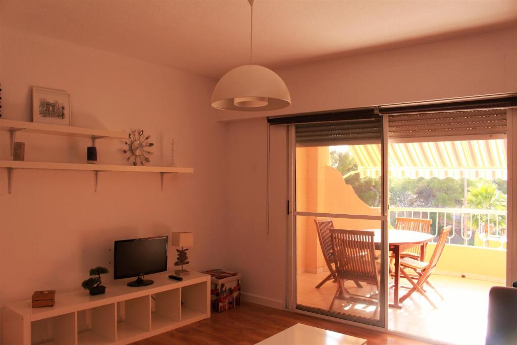 a living room with a television and a table with a dining room at Coveta Beach Apartament in El Campello