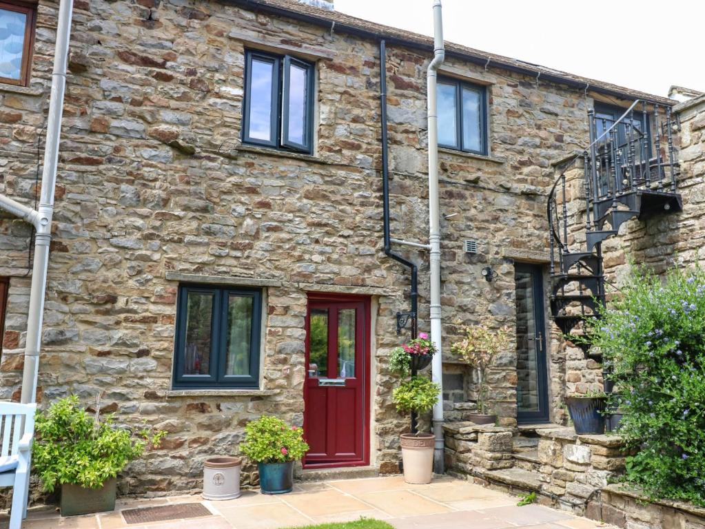 an old stone house with a red door at Kernot Cottage in Richmond