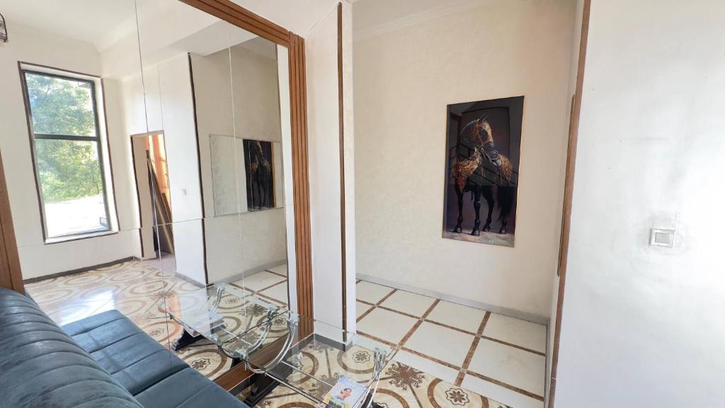a living room with a blue couch and a mirror at Sohil Hotel in Stantsiya Kyzyl-Tukumachi