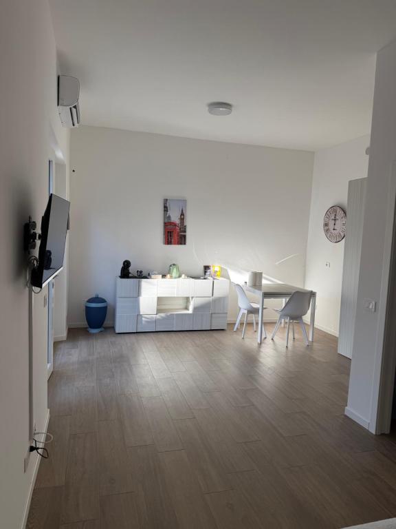 a white living room with a table and chairs at Artexia residence DIAMANTE A1 in Valenza