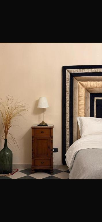 a bedroom with a bed and a table with a lamp at Neaiton in Noto