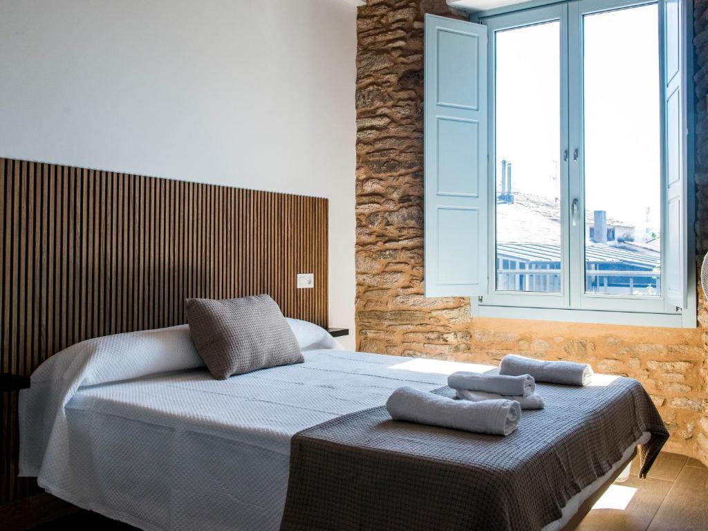 a bedroom with a bed with two towels on it at A Calexa Sarria nº4 in Sarria
