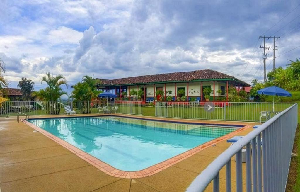 a swimming pool in front of a house at Finca Hotel Caracolí I A 15 Minutos del Parque del Café in Montenegro