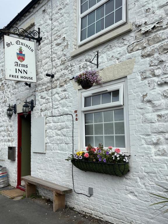 a window with a flower box on the side of a building at Saint Quintin Hotel in Harpham