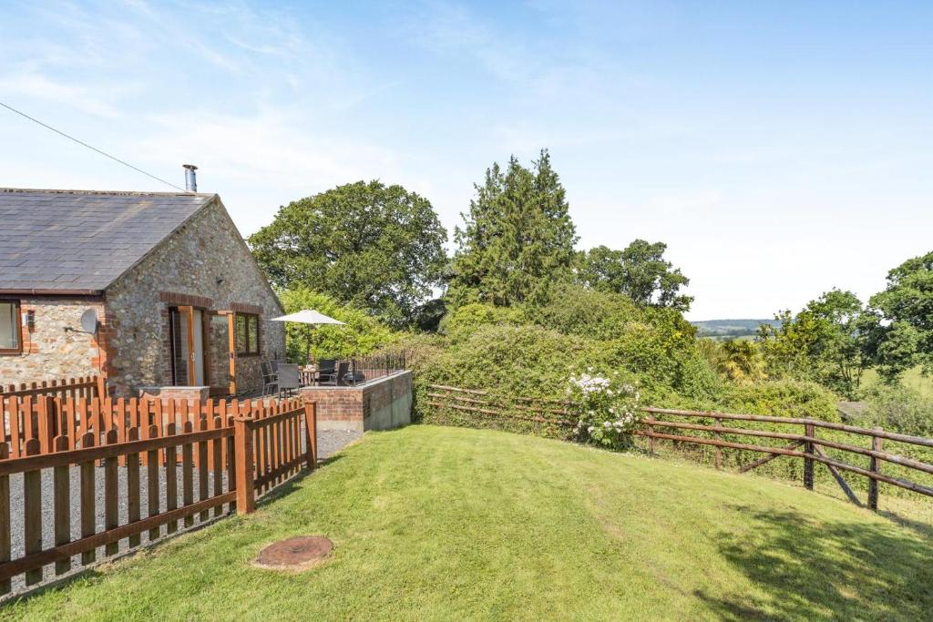 a stone cottage with a wooden fence and a yard at 3 Bed in Whitchurch Canonicorum oc-43395 in Whitchurch Canonicorum