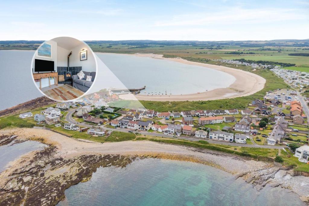 an aerial view of a house next to a beach at 5 Bed in Beadnell oc-24955 in Beadnell
