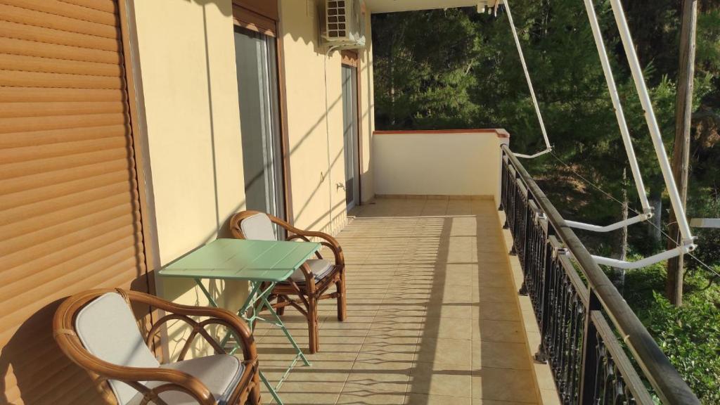a patio with two chairs and a table on a balcony at Vasiliki Bay in Vasiliki