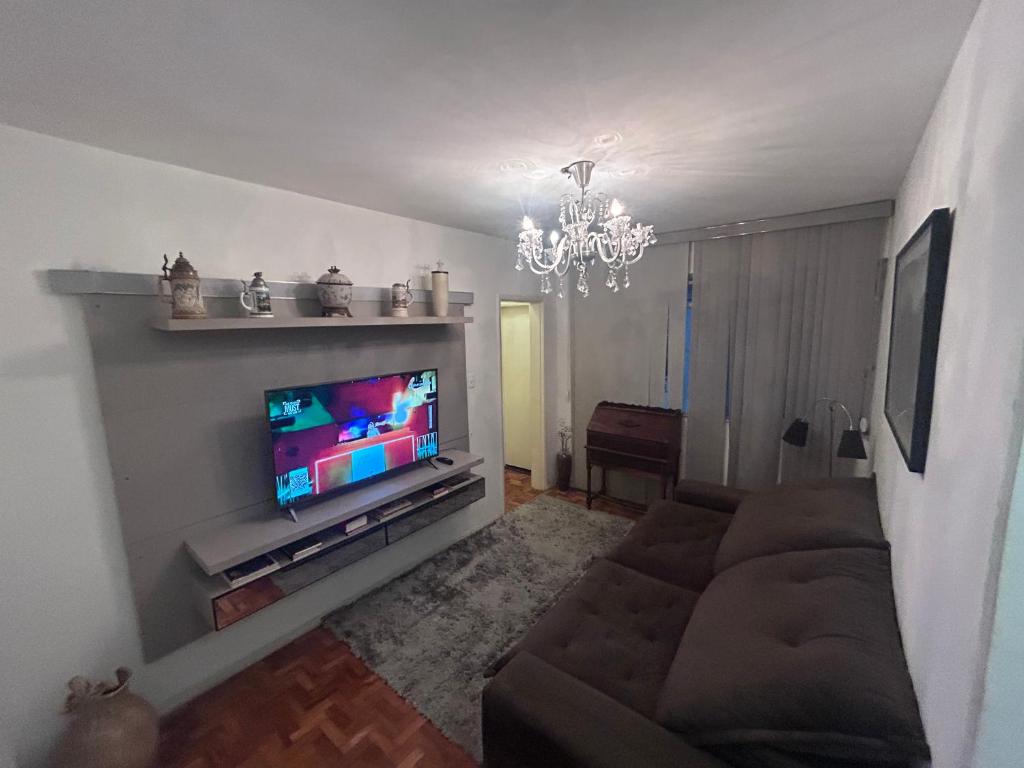 a living room with a couch and a flat screen tv at Lindo Apartamento próximo ao Centro in Juiz de Fora