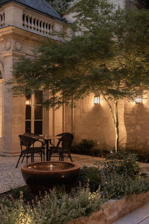 a table and two chairs in front of a building at Hotel des Quinconces Bordeaux Centre in Bordeaux