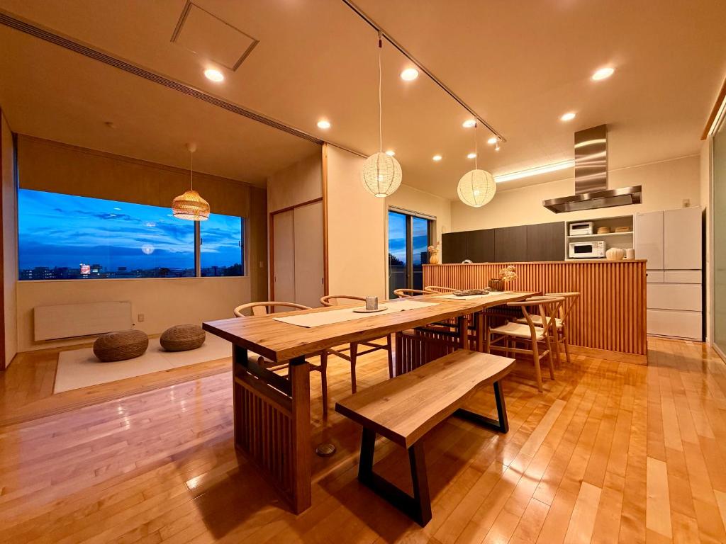 a dining room with a long table and chairs at Grand Opening SORA Yunokawa Penthouse in Hakodate