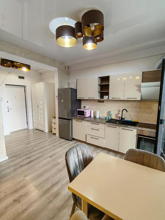 a large kitchen with a table and a table and chairs at MEM Studio in Mamaia Sat/Năvodari