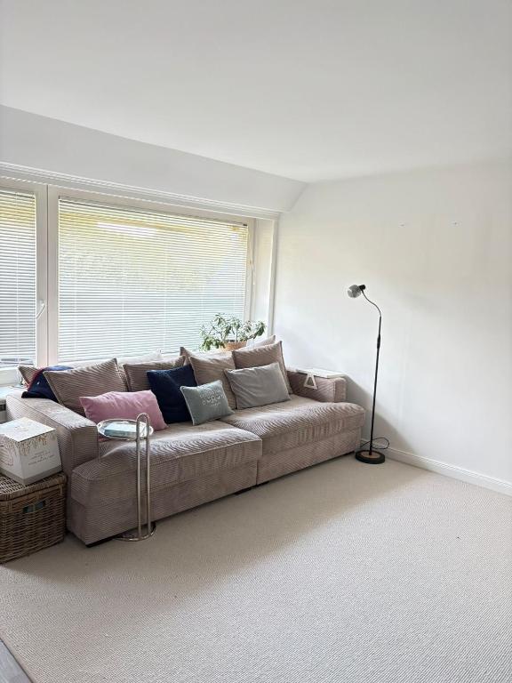 ein Wohnzimmer mit Sofa und Fenster in der Unterkunft Syltfisch in Sylt