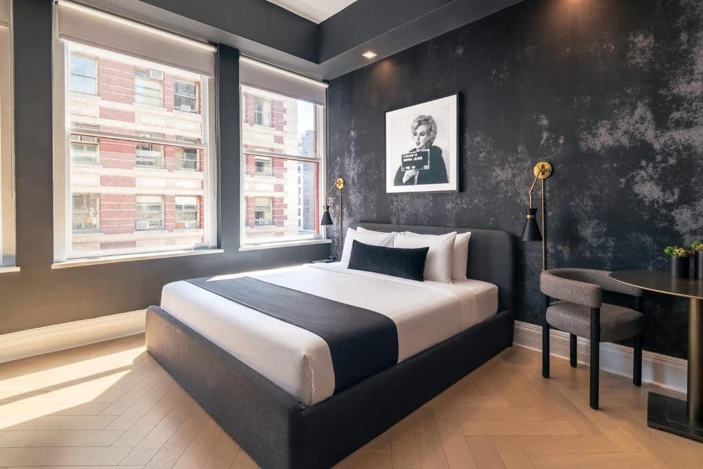a bedroom with a bed and a table and window at Broadway Hotel in the Flatiron District in New York
