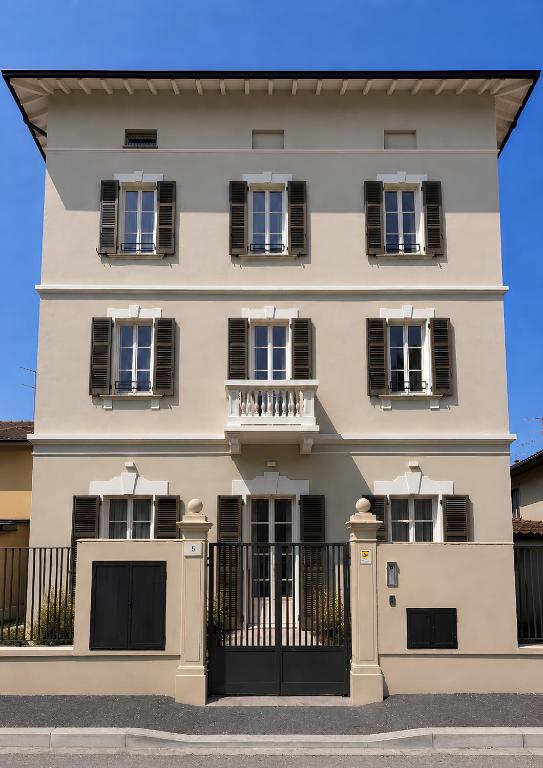 a large white building with black shuttered windows at Flowers Liberty Suites in Brescia