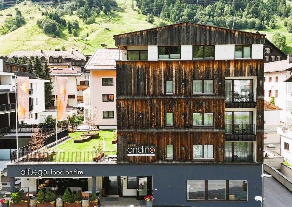 an apartment building with a wooden facade in a city at Hotel Andino in Sankt Anton am Arlberg
