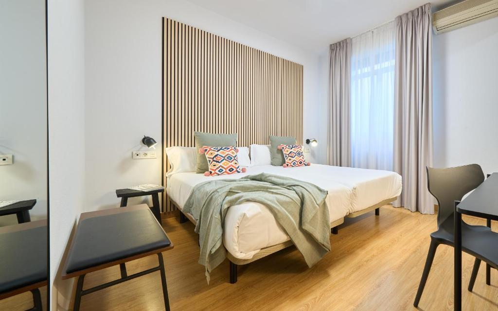 a hotel room with a bed and a chair at Hotel Centro Vitoria AutoCheckIn in Vitoria-Gasteiz