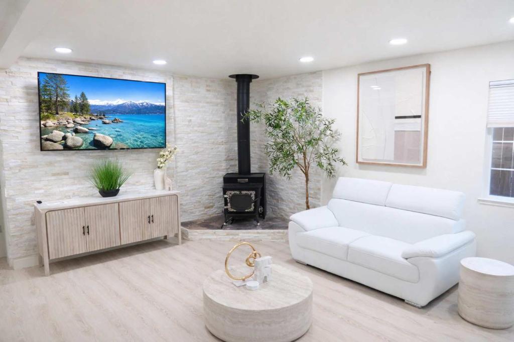 a living room with a white couch and a tv at Modern Tahoe Retreat in South Lake Tahoe