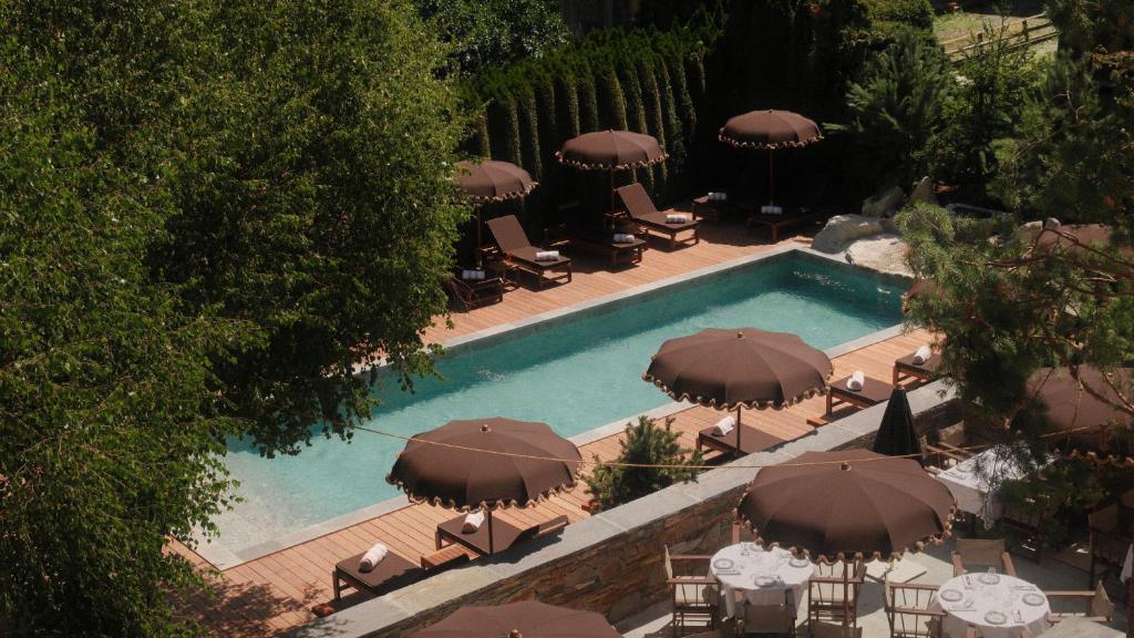 an overhead view of a swimming pool with umbrellas at Lodge Park in Megève