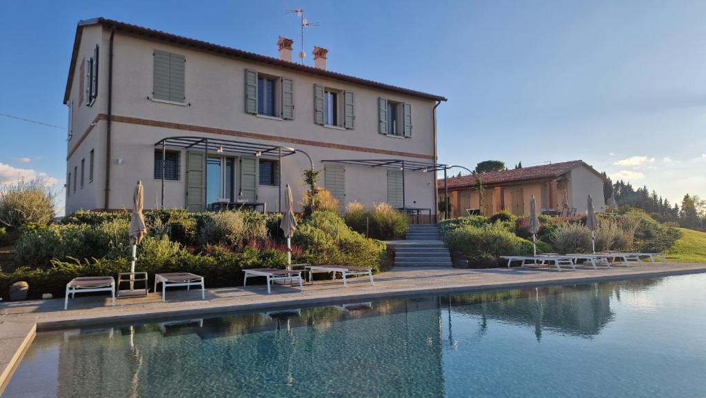 a house with a swimming pool in front of a building at Podere Mantignano 2 in Faenza