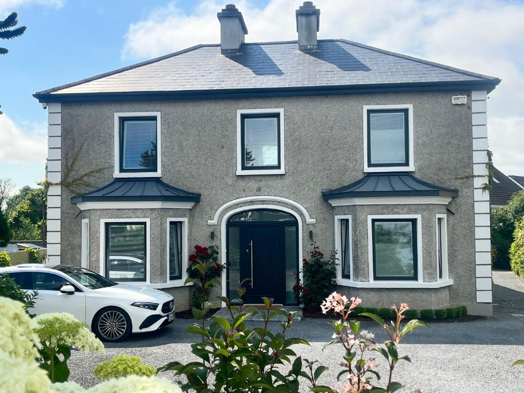 a house with a car parked in front of it at Lavally House in Gort