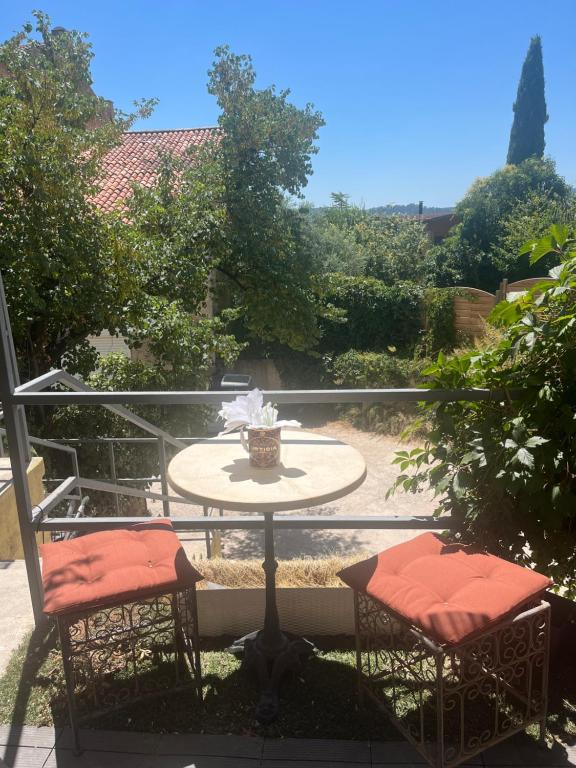 a patio with two chairs and a table on a balcony at L écrin du Luberon in Cadenet