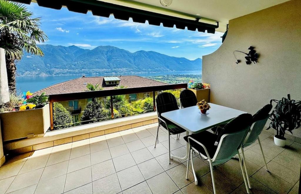 a balcony with a table and chairs and a large window at Ferienwohnung C04 in Orselina