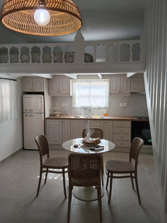 a kitchen with a table and chairs and a kitchen with a refrigerator at Liodentro House in Karpathos