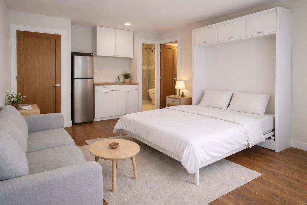 a bedroom with a large white bed and a couch at Bolishka Whispers, Spacious Bright Studio accom in Galway