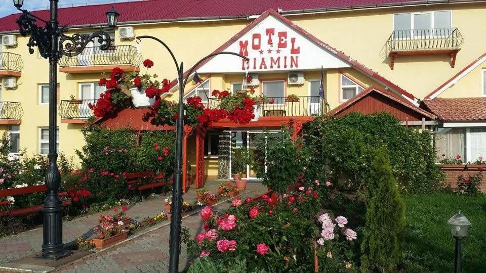 a hotel with flowers in front of a building at Motel Biamin in Tăşnad