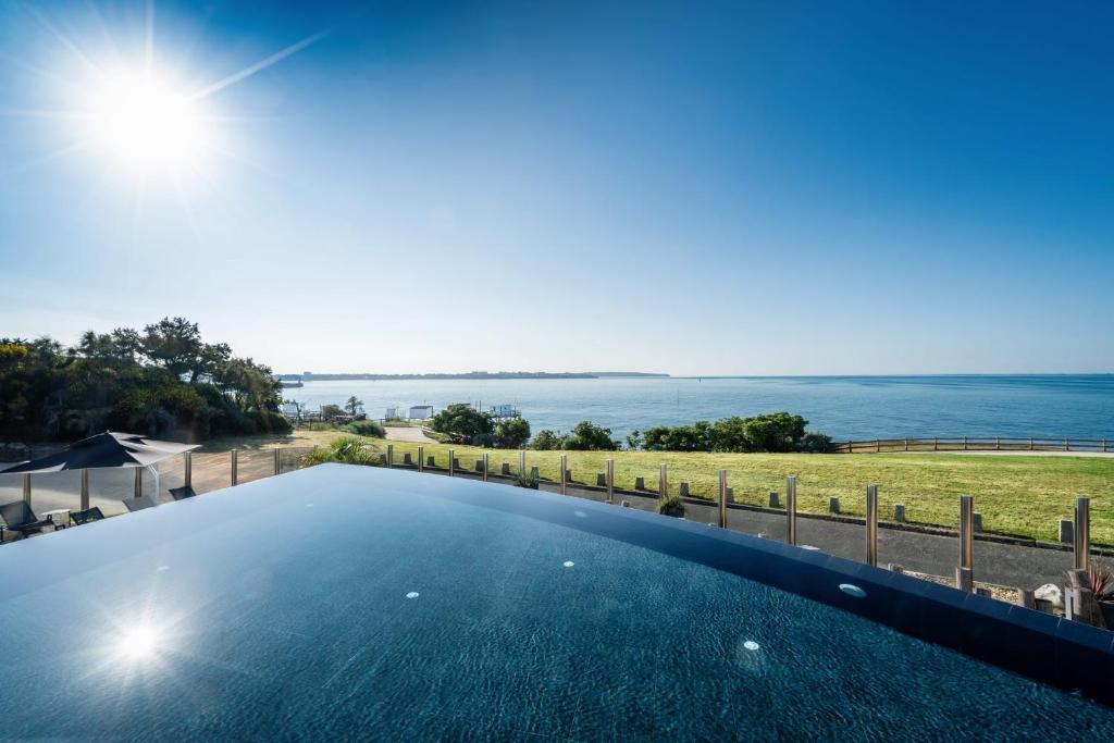 an infinity pool with a view of the water at Thalazur Royan - Hôtel & Spa in Royan