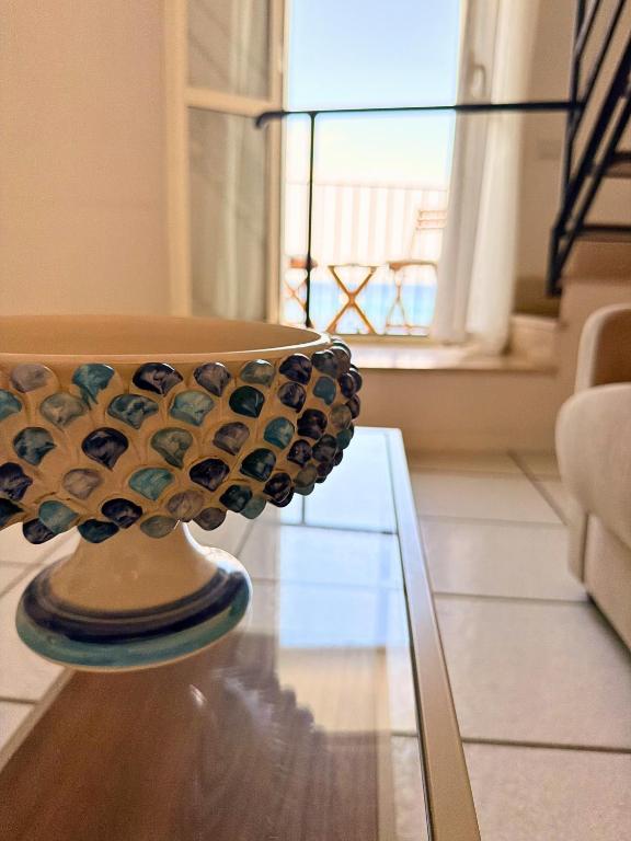 a vase sitting on top of a glass table at The Six Ortigia Residences in Syracuse