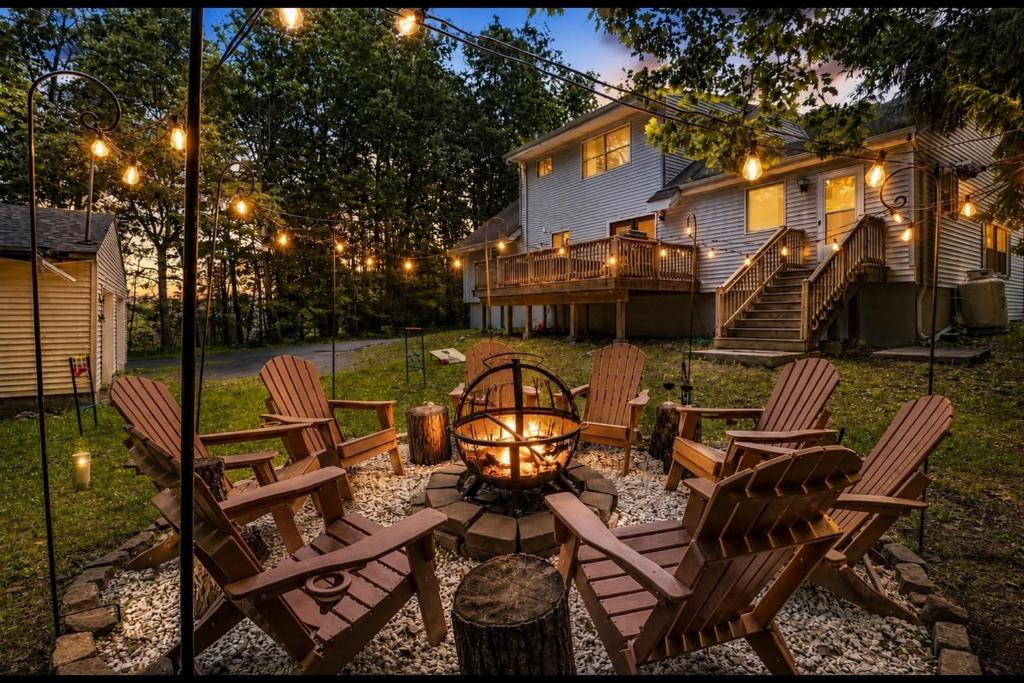 a backyard with chairs and a fire pit and a house at Lake Access & Private Hot Tub at Poconos Home! in White Haven