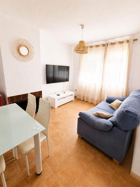 a living room with a blue couch and a table at Apartamento Chicago in Mazagón