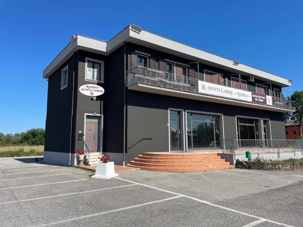 a black building with a parking lot at Affittacamere Ramina in San Giuseppe