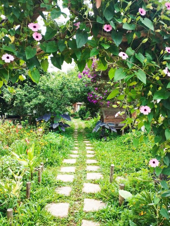 a path through a garden with pink flowers at Nhà Để Chill Homestay in Da Lat