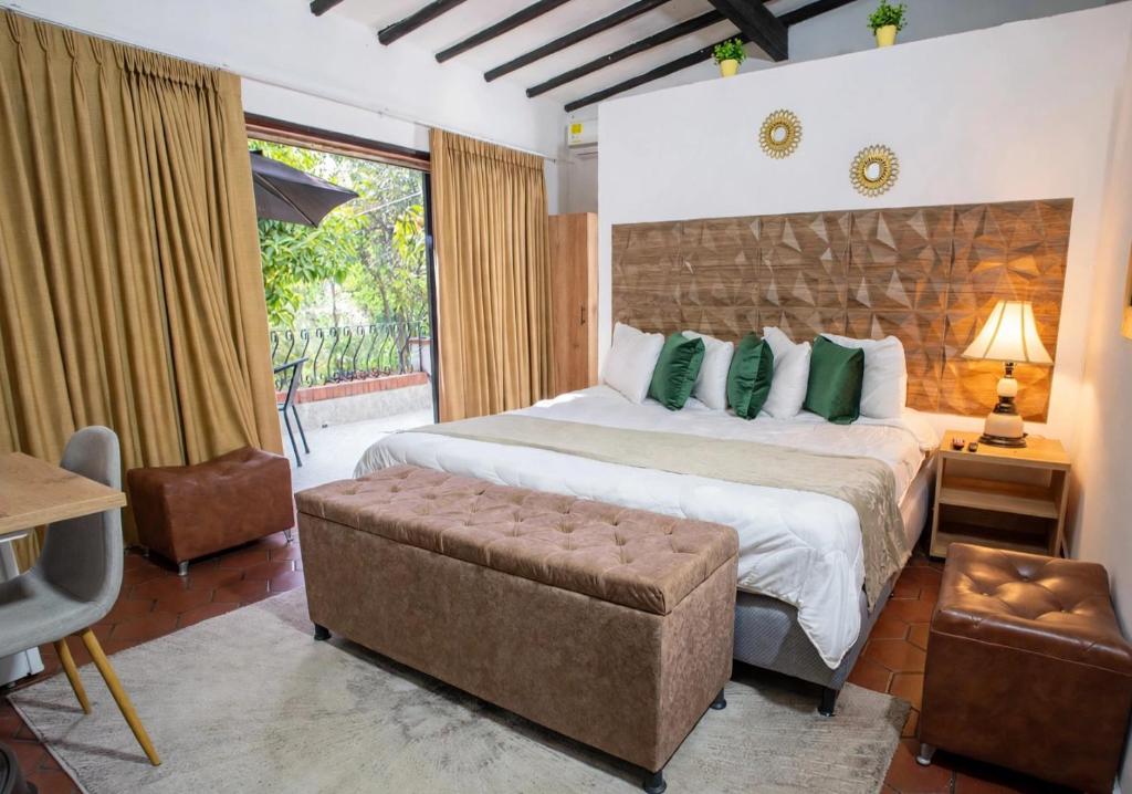 a bedroom with a large bed and a couch at Aguacatala Hotel Boutique in Medellín