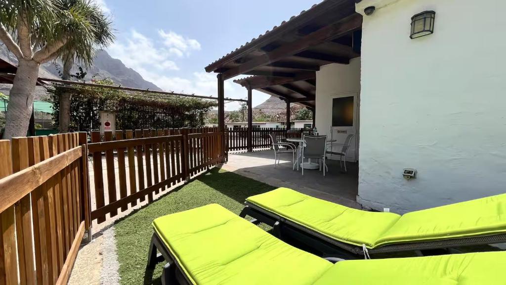 a patio with two chaise lounges and a house at Finca House by Fataga Maspalomas in San Bartolomé