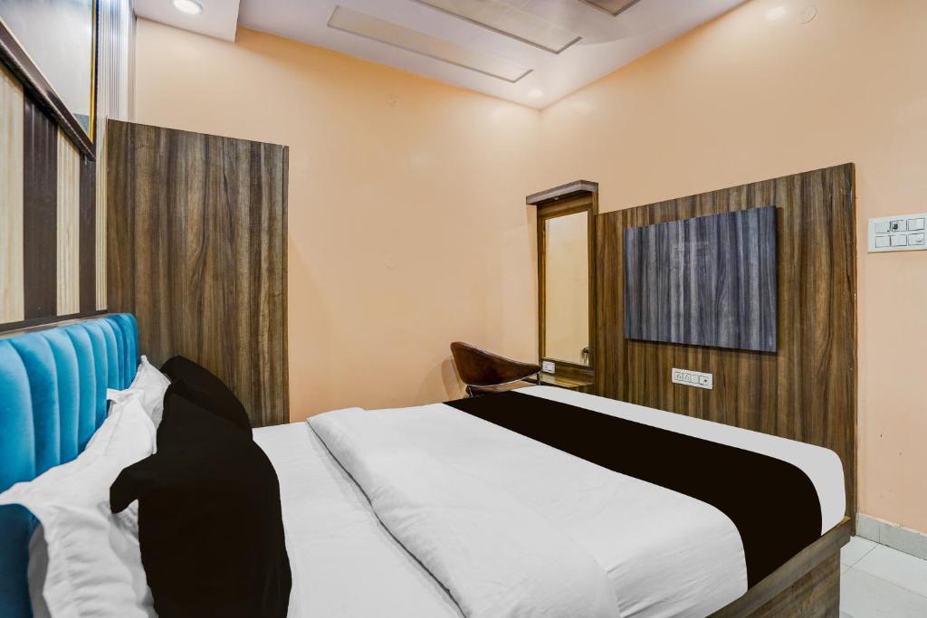 a bedroom with a white bed and a blue headboard at Hotel O Rameshwar Inn in Prayagraj