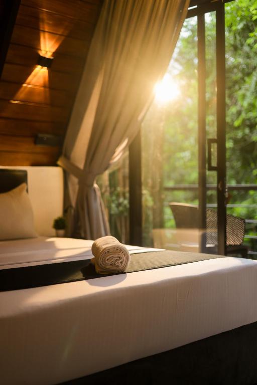a bedroom with a bed with a towel on it at Forest Face Lodge in Gurudeniya