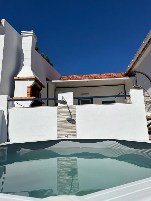 a villa with a swimming pool in front of a house at Casa Da Aldeia in Alcácer do Sal