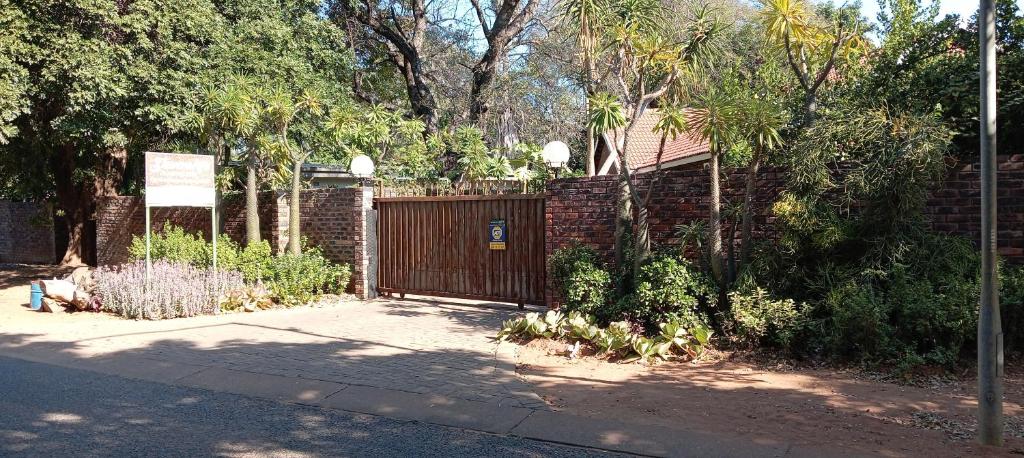 a fence with a wooden gate in a yard at Stevenski's Guesthouse in Lephalale
