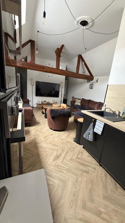 a living room with wooden floors and a room with couches at Le Pétillant in Cramant